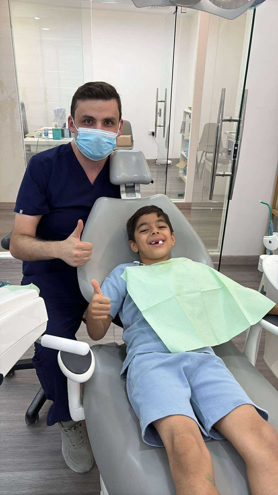 د. ماجد صباح مع طفل على كرسي الأسنان في العيادة د. ماجد صباح مع طفل على كرسي الأسنان في العيادة